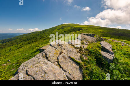 Berglandschaft mit Steinen Verlegung unter dem Rasen oben auf dem Hügel unter dem bewölkten Sommerhimmel Stockfoto