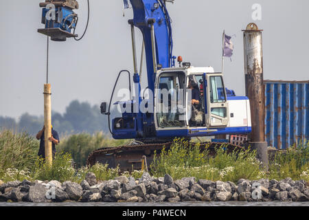 Hydraulischer kran Montage Holz- Poller Pfosten auf Wasser Stockfoto