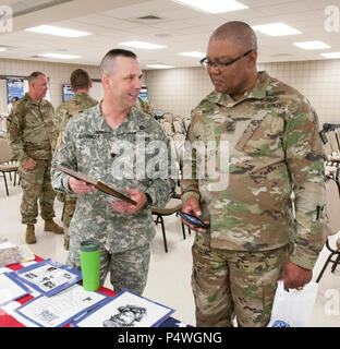 ROBINSON-Manöver-TRAINING-CENTER, N. Little Rock, Arkansas: – Oberstleutnant Richard Garringer (links) und Master Sgt. Dishoungh White Blick auf eine Ausstellung Investitur Arkansas Nationalgarde Chancengleichheit Büro Diversity Day bei Chappell Armory, Mittwoch, 10. Mai 2017. Die Veranstaltung war eine Gelegenheit, die Vielfalt der Gesamtkraft zu feiern und wer wir sind und wer wir nicht sind, unabhängig von Rasse, Geschlecht, Nationalität, Religion oder Behinderung zu umarmen. Mehr als 70 Soldaten bekamen Informationen über Vielfalt, ein Geschmack von kultureller Unterhaltung und ethnischen Lebensmitteln und Displays mit Informationen über Stockfoto