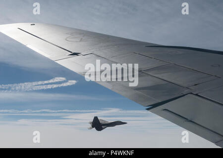 EIELSON AIR FORCE BASE, Alaska - ein US Air Force F-22 Raptor multi-role Fighter Aircraft pilot zugeordnet Joint Base Elmendorf-Richardson, Fliegen in der Nähe der Flügel einer KC-135 Stratotanker T von Fairchild Air Force Base, 9. Mai 2017, während der nördliche Rand 2017 (NE 17), über die Gemeinsame Pacific-Alaska Bereich Komplex. NE 17 ist Alaska's Premier gemeinsame Ausbildung Übung darauf ausgerichtet, den Betrieb, Techniken und Verfahren sowie zur Praxis wie Interoperabilität zwischen den Diensten zu verbessern. Tausende von Teilnehmern aus allen Diensten, Flieger, Soldaten, Seemänner, Marinesoldaten und Küstenwache aus dem aktiven Dienst, Rese Stockfoto