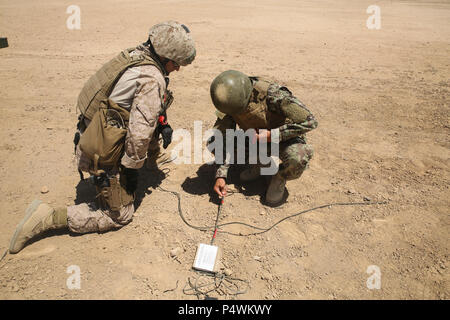 Ein US-Marine mit Task Force Südwesten Uhren einer afghanischen nationalen Armee Soldat mit dem 215 Corps Riegel Sprengladungen auf eine Amtsleitung im Camp Shorabak, Afghanistan, 10. Mai 2017. Einige Marinesoldaten und Matrosen mit TFSW sind Unterstützung bei der Unterweisung und praktische Anwendung der Explosionsgefahr Reduzierung Kurs neben ihrer afghanischen Kollegen. Das Training vermittelt die Soldaten mit das Wissen und die Fähigkeiten, die benötigt werden, um die Bedrohungen der Improvised Explosive Devices zu überwinden. Stockfoto