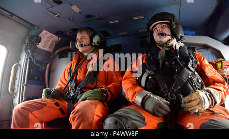 Golf von ALASKA - Generalleutnant Ken Wilsbach, Commander, US-Alaska-Command und Aviation Maintenance Technician 2. Klasse Joe Garofalo vorbereiten, Arleigh Burke-Klasse geführte Flugkörper Zerstörer USS O'Kane (DDG-77) fahren in einem U.S. Coast Guard MH-60 t Jayhawk befestigt Air Station Kodiak, Alaska, im Golf von Alaska. Nördlichen Rand 2017 ist Alaskas Premiere Joint-Übung zur Praxis Operationen, Techniken und Verfahren sowie die Interoperabilität zwischen den Diensten zu verbessern. Tausende von Teilnehmern aus den Diensten; Matrosen, Flieger, Soldaten, Marines und Küstenwache Person Stockfoto