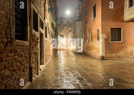 Leere alte Straße in Venedig durch die regnerische Nacht Stockfoto