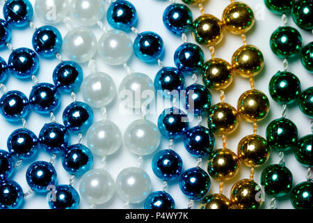 Makro Zusammenfassung Hintergrund mit bunten Mardi Gras Perlenketten zufällig auf eine weiße Fläche angeordnet Stockfoto