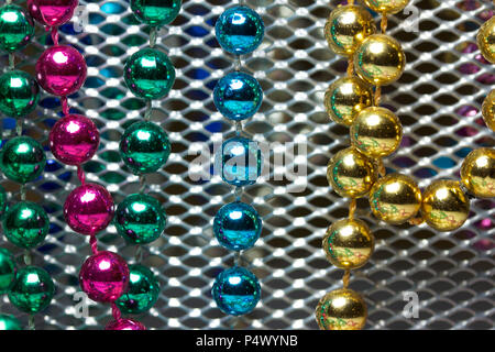 Makro Zusammenfassung Hintergrund mit bunten Mardi Gras Perlenketten zufällig auf eine weiße Fläche angeordnet Stockfoto