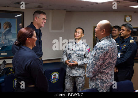 SONGKHLA, Thailand (10. Mai 2017) Cmdr. Claudine Caluori, Kommandierender Offizier der Arleigh-Burke-Klasse geführte Anti-raketen-Zerstörer USS Sterett (DDG104) und Kapitän David Bretz, Commodore von Destroyer Squadron 31, sprechen sie mit Royal Thai Navy Capt. Chaksawat Saiwong, Republik Singapur Marine Oberstleutnant Leon Chua und Bangladesh Navy hinten Adm. M. Shafiul Azim während einer Konferenz an Bord Sterett presail zur Unterstützung der multilateralen Übung CARAT. CARAT ist eine Reihe von jährlichen maritime Übungen zur Stärkung von Partnerschaften und die Erhöhung der Interoperabilität durch bilaterale und multilaterale Verpflichtungen ein Stockfoto