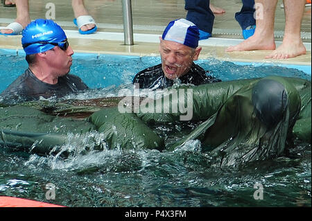 Drei Italienische Fallschirmjäger von der Italienischen Armee Folgore Brigade nasse Seide Schulungen durchführen. Eine Italienische Fallschirmjäger schwimmt unter dem Fallschirm in der Italienischen Armee Folgore Brigade swimming Pool an Lustrissimi Italienisch Training Area, Livorno, Italien, 9. Mai 2017. Diese Übung ist Teil der vorsätzliche Wasser betrieb Einarbeitung Training vor dem Sprung am Gardasee, Italien ( Stockfoto