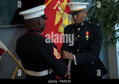 Leutnant Mitchell Harrison gibt Staff Sgt. Cheops Dieujuste, ein Recruiter bei der Rekrutierung der Unterstation Brandon, RS Orlando, ein Silver Dollar während einer Inbetriebnahme Zeremonie an die Embry-Riddle Aeronautical University College in Daytona Beach, Florida, 10. Mai 2017. Die Zeremonie gedacht Harrisons "Kommission als Leutnant in der Marine Corps. Harrison abgeschlossen Die 10-wöchigen Officer Kandidaten Schule und bereitet sich für die Grundschule im Juli 2017 zu verlassen. Stockfoto