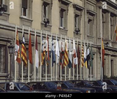 BANDERAS AUTONOMICAS EN LA FACHADA DEL PALACIO DEL SENADO DE LA PLAZA DE LA MARINA ESPAÑOLA. Lage: SENADO - AUSSEN, MADRID, SPANIEN. Stockfoto