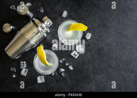 Alkohol Cocktail mit Zitrone und Eis. Gin Tonic fizz oder gimlet Cocktail auf schwarzen Hintergrund, kopieren. Stockfoto
