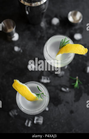 Alkohol Cocktail mit Zitrone, Rosmarin und Eis. Gin Tonic fizz oder Gimlet auf schwarzem Hintergrund, kopieren. Stockfoto
