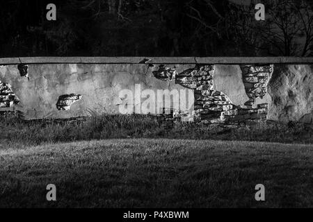 Alte steinerne Mauer bröckelt bei Nacht Stockfoto