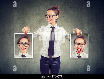 Junge fröhliche Frau in Gläsern mit Bildern in der Hand, mit guten und schlechten Gefühle in Stimmungsschwankungen und lächelnd an positiven Selbst Stockfoto