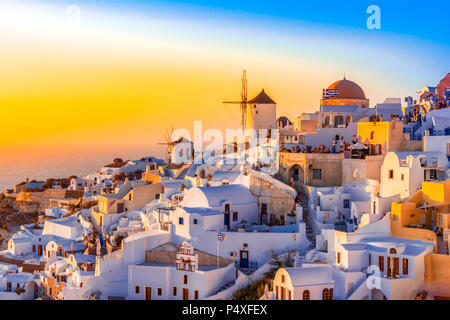 Sonnenuntergang in Oia, Santorini, Griechenland. Traditionelle und berühmte weisse Häuser und Kirchen mit blauen Kuppeln auf die Caldera, Ägäis. Stockfoto
