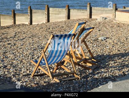 Liegestühle am Strand Whitstable, Kent Stockfoto