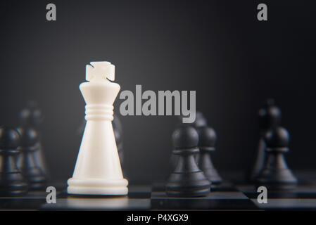 Schach auf Schachbrett. weiße König gegen schwarze Bauer. Führung, Macht, Helden und Kampf Konzept. Selektive und Soft Focus Stockfoto