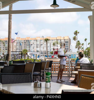 Dunedin, Florida, USA. Kellnerin im Gespräch mit den Kunden in einem Restaurant am Meer Stockfoto