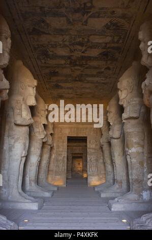 Ägyptische Kunst Großen Tempel von Ramses II (1290-1224 v. Chr.). Grabkunst Tempel in den Fels gehauen. Blick aus dem ersten Raum, mit acht Statuen von Ramses II. als der Gott Osiris. Abu Simbel. Ägypten. Stockfoto