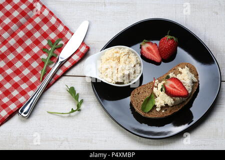 Scheiben Brot mit Käse und Erdbeeren auf die Oberseite. Stockfoto