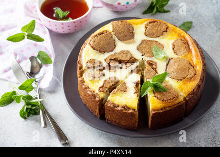 Käsekuchen und Minze Tee Tasse. Schokolade New York Cheesecake und Pfefferminztee Schale auf konkreten Hintergrund. Stockfoto