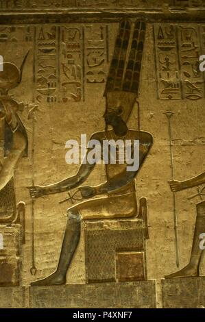 Ptolemäischen Tempel der Hathor und Maat. Polychrome Reliefs, die das Interieur zieren. Gott Amun. Sitzende Figur. Deir el-Medina. Ägypten. Stockfoto