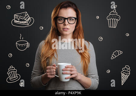 Schöne Frau trinkt Tee und Süßigkeiten essen Stockfoto