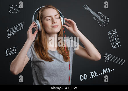 Schöne Frau, ihre Augen zu schließen und die Wiedergabe von Musik Stockfoto