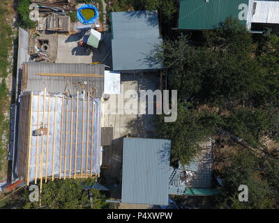 Slavjansk-auf-Kuban, Russland - 10. September 2017: Wohnhaus und Nebengebäuden. Das Dach des Hauses reparieren. Feuchtigkeit Isolierung unter Metall. Stockfoto