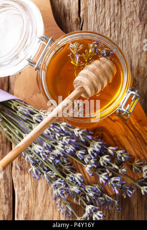 Lavender flüssiger Honig in einem Glas close-up auf einem Tisch. Vertikal oben Ansicht von oben Stockfoto
