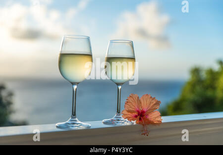 Romantische Momente im Sommer bei Sonnenuntergang mit zwei Gläser Weißwein-romantischen Urlaub Konzept mit schönen Blick auf die tropischen Strand und Echtheitszertifikate Stockfoto