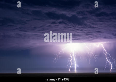 Blitzeinschläge und Blitze erhellen dramatische Gewitterwolken während eines Sommergewitters in der Nähe von EADS, Colorado Stockfoto