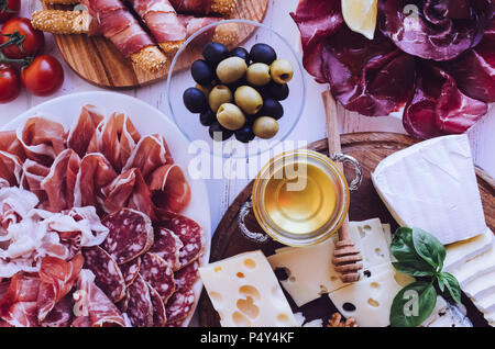 Tabelle mit mediterranen Vorspeisen, Tapas und Antipasti. Verschiedene italienische Küche. Leckerer Snack auf Party oder Picknick. Schneidbrett mit mir Stockfoto