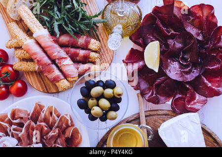 Tabelle mit mediterranen Vorspeisen, Tapas und Antipasti. Verschiedene italienische Küche. Leckerer Snack auf Party oder Picknick. Schneidbrett mit mir Stockfoto