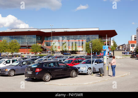 Lulea, Schweden - 20. Juni 2018: Eine Frau kauft ein Ticket in einem Automaten am Parkplatz vor der öffentlichen Bibliothek in der Innenstadt von Lulea. Stockfoto