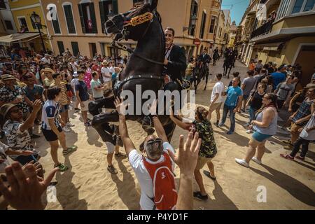 Der Parc de la Ciutadella, Spanien. 23. Juni, 2018: Ein "caixer' (Reiterin) bäumt sich auf seinem Pferd von einer jubelnden Menge vor der 'Caragol des Geboren" Parade am Vorabend des traditionellen ant Joan" (Saint John) Festival in Ciutadella de Menorca Credit: Matthias Oesterle/Alamy Leben Nachrichten umgeben Stockfoto