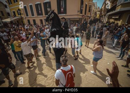 Der Parc de la Ciutadella, Spanien. 23. Juni, 2018: Ein "caixer' (Reiterin) bäumt sich auf seinem Pferd von einer jubelnden Menge vor der 'Caragol des Geboren" Parade am Vorabend des traditionellen ant Joan" (Saint John) Festival in Ciutadella de Menorca Credit: Matthias Oesterle/Alamy Leben Nachrichten umgeben Stockfoto