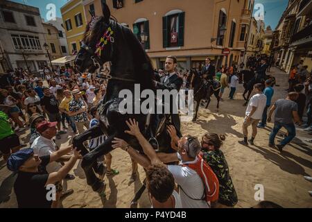 Der Parc de la Ciutadella, Spanien. 23. Juni, 2018: Ein "caixer' (Reiterin) bäumt sich auf seinem Pferd von einer jubelnden Menge vor der 'Caragol des Geboren" Parade am Vorabend des traditionellen ant Joan" (Saint John) Festival in Ciutadella de Menorca Credit: Matthias Oesterle/Alamy Leben Nachrichten umgeben Stockfoto