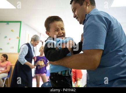 Vater und Sohn aus Honduras Rest an einem McAllen, TX, Unterstand für Zugewanderte Familien durch US-Einwanderungs- und Zollbehörden freigegeben und in Erwartung Disposition der Abschiebung Fällen verstopfen die Gerichte. Stockfoto