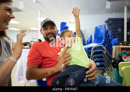 Vater und Sohn aus Honduras Rest an einem McAllen, TX, Unterstand für Zugewanderte Familien durch US-Einwanderungs- und Zollbehörden freigegeben und in Erwartung Disposition der Abschiebung Fällen verstopfen die Gerichte. Stockfoto