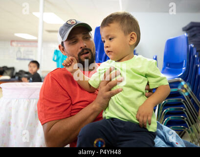 Vater und Sohn aus Honduras Rest an einem McAllen, TX, Unterstand für Zugewanderte Familien durch US-Einwanderungs- und Zollbehörden freigegeben und in Erwartung Disposition der Abschiebung Fällen verstopfen die Gerichte. Stockfoto