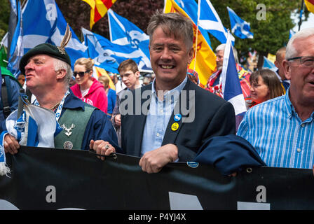 Stirling, Stirlingshire, Großbritannien. 23. Juni 2018. SNP MSP für Clackmannanshire und Dunblane, Keith Brown, Märsche auf der Vorderseite der Masse halten ein Banner mit der Aufschrift "Unabhängigkeit Jetzt'' während der März. Tausende schottische Unabhängigkeit Unterstützer marschierten durch Stirling und Bannockburn als Teil der''˜ alle unter einem Banner "Protest, als die Koalition zielt darauf ab, eine solche Veranstaltung zu laufen, bis Schottland ist''˜ Kostenlose Kreditkarte: Stewart Kirby/SOPA Images/ZUMA Draht/Alamy leben Nachrichten Stockfoto