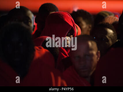 Malaga, Spanien. 23. Juni 2018. Migranten gesehen durch rote Decken nach ihrer Ankunft am Hafen von Malaga. Mitglieder der Spanischen Sicherheit auf See gerettet 314 Migranten an Bord sechs Jollen in der Nähe der Küste von Malaga und brachte am Hafen von Malaga, wo sie durch das Spanische Rote Kreuz unterstützt wurden. Insgesamt wurden 769 Migranten gerettet dieser Samstag von Alboran See, der Kanarischen Inseln und der Straße von Gibraltar an Bord 25 Jollen. Credit: Jesus Merida/SOPA Images/ZUMA Draht/Alamy leben Nachrichten Stockfoto