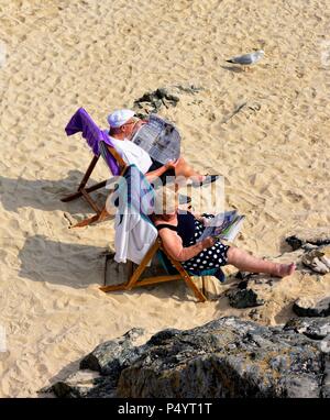 Ältere Paare beim Sonnenbaden auf Porthgwidden Beach St Ives Cornwall England Großbritannien Stockfoto