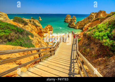 Holzsteg zu malerischen Praia do Camilo in Lagos, Algarve, Portugal. Die lange Treppe zu klaren Gewässer der Algarve. Sommer Urlaub in Europa. Stockfoto