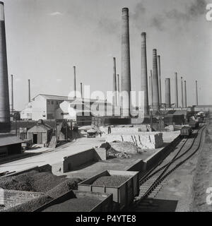 1950er, historisch, Außenansicht eines Teils der riesigen Ziegelwerke der London Brick Company in Stewartby, Bedfordshire, England, Großbritannien, zeigt die Masse der Schornsteine, die die zahlreichen Brennöfen belüfteten, die die Ziegel abfeuerten. Es gab bis zu 162 Schornsteine auf dem Gelände. - Ein britisches Unternehmen, die London Brick Company, war der größte Ziegelsteinhersteller der Welt zu dieser Zeit, der "Oxford Clay" abbaute, den organischen Schlammstein oder Mineral, der Teile Südenglands unterlag und der der Rohstoff für den berühmten London Brick war. Stockfoto