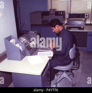 Dahran, 1965, Saudi Mann bei der Arbeit im Computerraum an der Hochschule für Erdöl und Mineralien, Saudi-Arabien. Die Hochschule wurde ein universty im Jahr 1975 und im Jahr 1986 war es, als der König Fadh Univeristy von Erdöl und Mineralien umbenannt. Dahran ist der Sitz von ARAMCO, die saudische Regierung Ölgesellschaft. 1935 Das erste Öl gut in Saudi-arabien war es gebohrt. Stockfoto