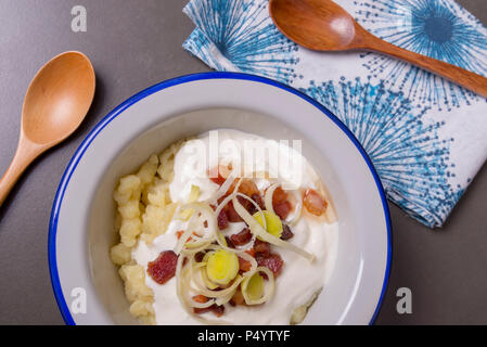 Bryndzove halusky. Traditionelle slowakische Gericht - kartoffelklöße mit gebratenem Speck, Käse und saurer Sahne. Stockfoto