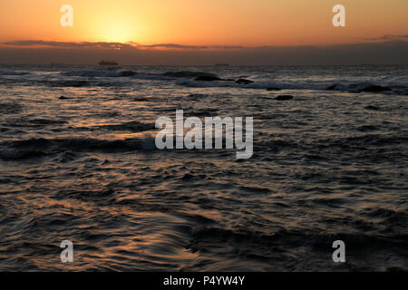 Landschaft, Durban, KwaZulu-Natal, Südafrika, golden Glow, Tagesanbruch, Sonnenaufgang, turbulenter Indischer Ozean, Blick auf Schiffe am Horizont, Umhlanga Rocks Strand Stockfoto