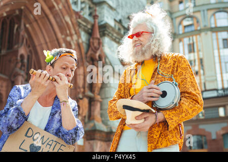 Hippy trägt blaue glänzende Jacke und floralen Kopfbügel Stockfoto