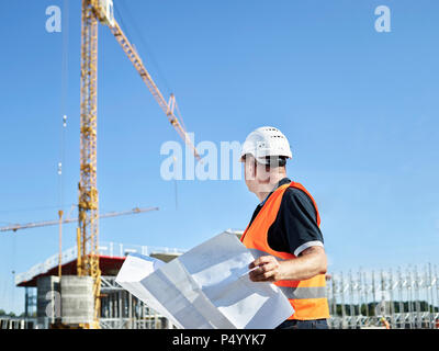 Bauarbeiter mit Blueprint auf der Baustelle Stockfoto